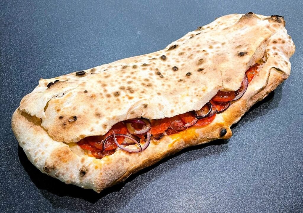 Panuozzo Dracula con salame piccante, cipolla, ‘nduja e fiordilatte della Pizzeria Fracchia di Torino